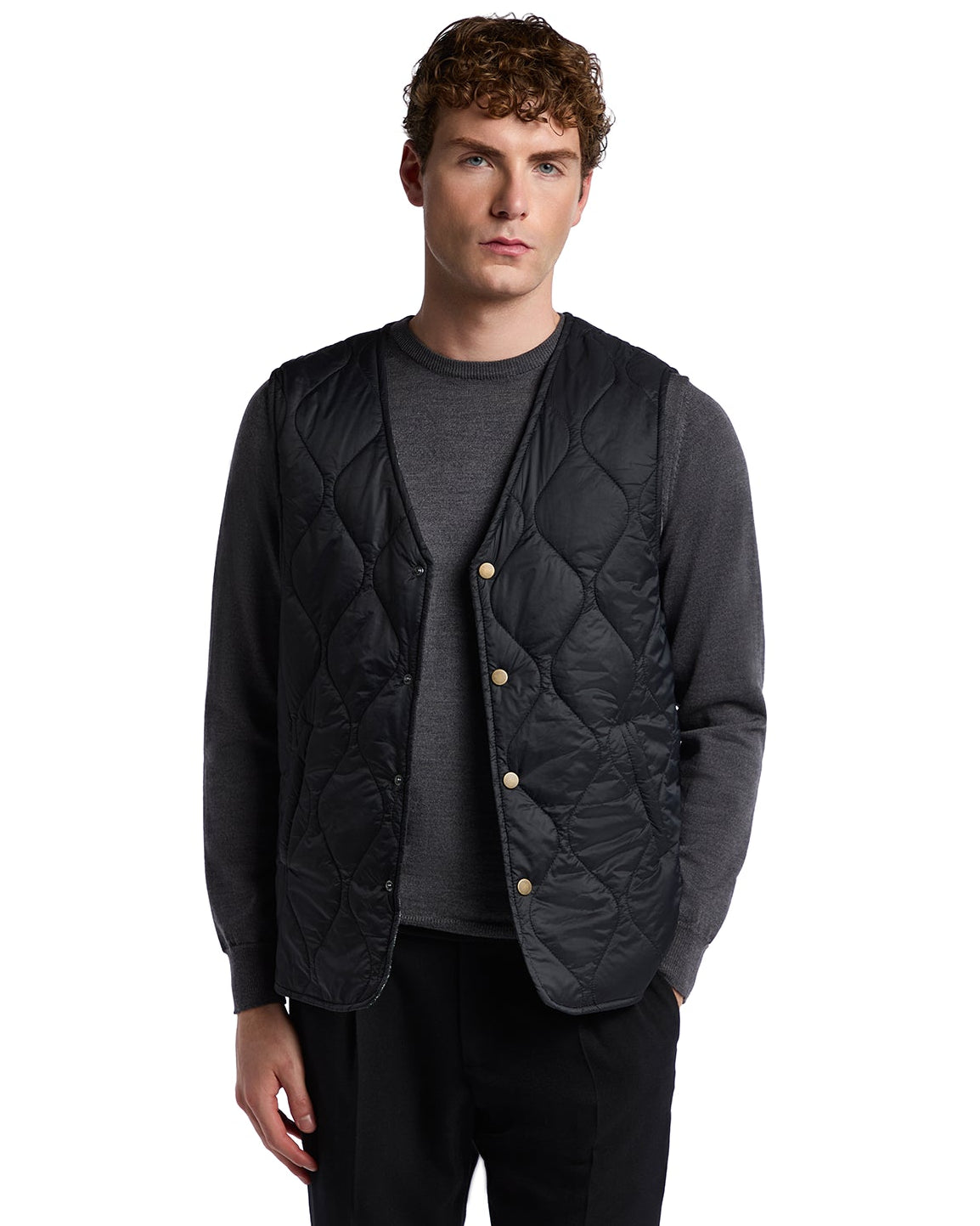 Black quilted vest with button closure, layered over a gray long-sleeve shirt, perfect for stylish layering.